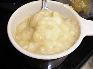 Measuring cup full of mashed banana