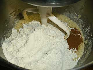 Flour, cinnnamon, baking soda  and baking powder are stirred into banana bread batter.