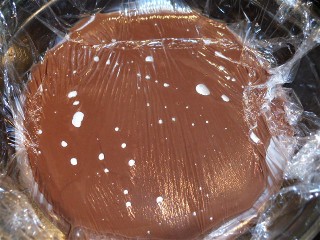 Chocolate pudding covered in plastic wrap.