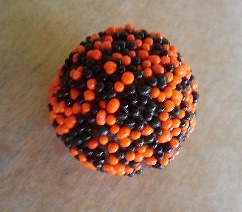 Halloween truffle covered in black and orange sprinkles.