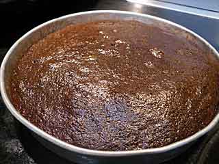 Baked layer of chocolate cake in pan.