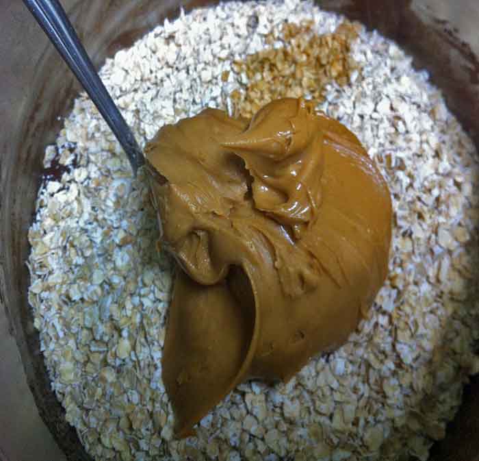 Oatmeal, peanut butter and vanilla extract being mixed into the cocoa coating.