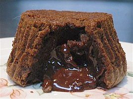 Chocolate lava cake with lava oozing out onto the plate.