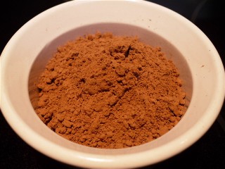 Dish of dark chocolate cocoa powder.