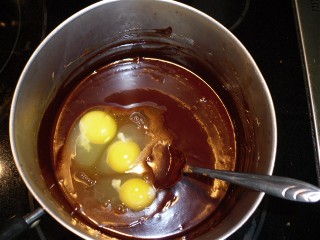 Three eggs added to melted chocolate mixture.